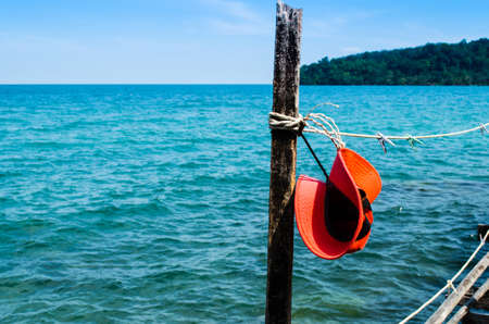 Red sun hat on robe with ocean blackground,koh kood,thailandの写真素材
