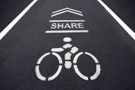 Sign on the cycling way meaning please share bike lanes for bikers.bicycles sign in the park with sunset light.の写真素材