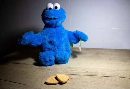 Cookie monster looking at two heart shaped cookiesの写真素材