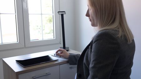 blonde girl working in an officeの写真素材