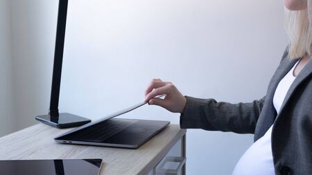 Hand opening a laptop and a phoneの写真素材