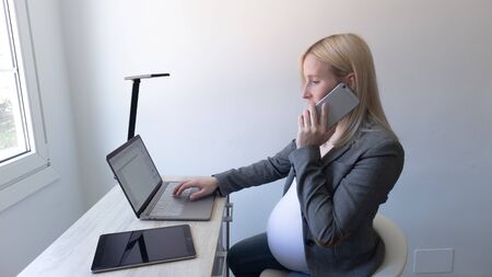 blonde girl calling on the phone and workingの写真素材