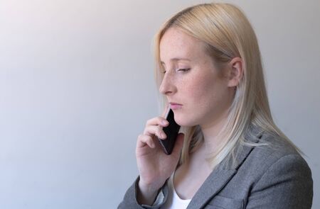 blonde girl calling on the phone and working at homeの写真素材