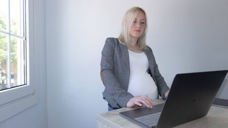 Pregnant working in officeの写真素材