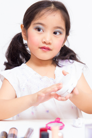 Little Asian child playing with mothers makeupの写真素材