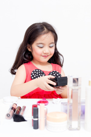Little Asian child playing with mothers makeupの写真素材