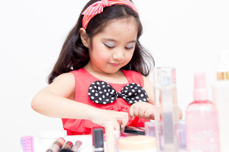 Little Asian child playing with mothers makeupの写真素材