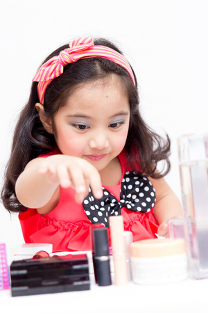 Little Asian child playing with mothers makeupの写真素材