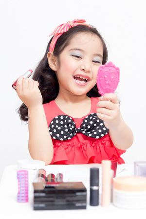 Little Asian child playing with mothers makeupの写真素材