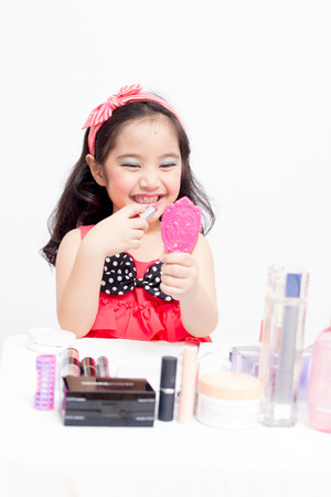 Little Asian child playing with mothers makeupの写真素材