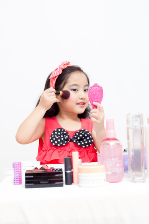 Little Asian child playing with mothers makeupの写真素材