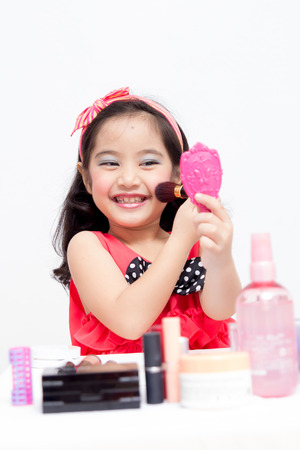 Little Asian child playing with mothers makeupの写真素材