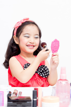 Little Asian child playing with mothers makeupの写真素材