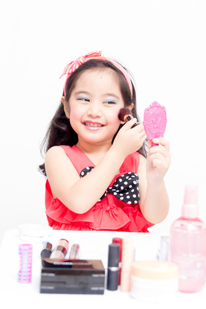 Little Asian child playing with mothers makeupの写真素材