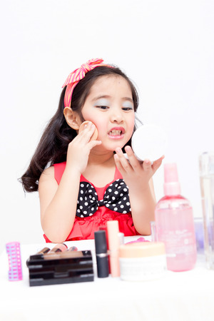 Little Asian child playing with mothers makeupの写真素材