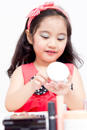 Little Asian child playing with mothers makeupの写真素材