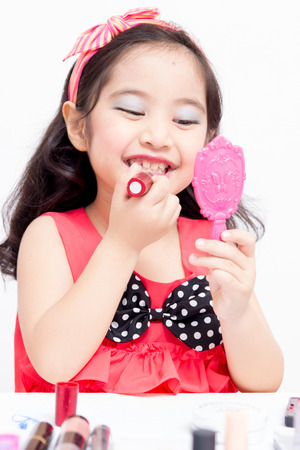 Little Asian child playing with mothers makeupの写真素材