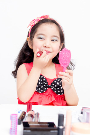 Little Asian child playing with mothers makeupの写真素材