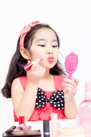 Little Asian child playing with mothers makeupの写真素材