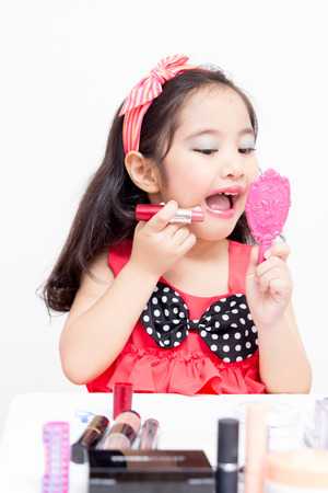 Little Asian child playing with mothers makeupの写真素材