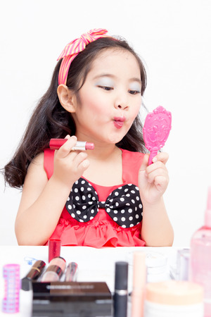 Little Asian child playing with mothers makeupの写真素材