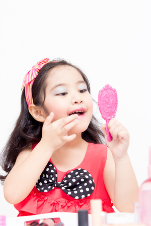 Little Asian child playing with mothers makeupの写真素材
