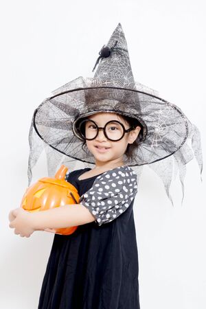 Surprise Happy witch child with pumpkin in Halloween dressの写真素材
