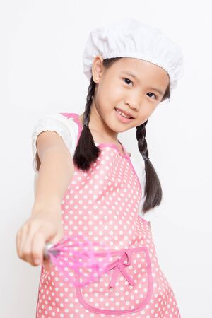 Little Asian cute chef wearing pink apronの写真素材