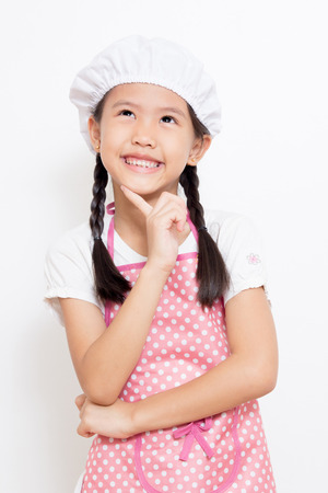 Little Asian cute chef wearing pink apron thinking actionの写真素材