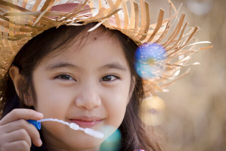 Happy Asian child playing bubble with straw stackの写真素材