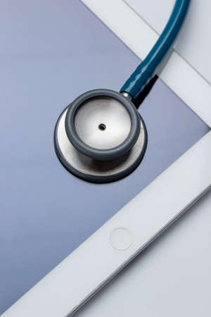 Healthcare and technology concept - close up of stethoscope and digital tablet pcの写真素材