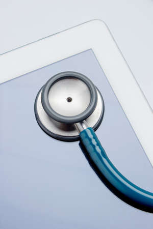 Healthcare and technology concept - close up of stethoscope and digital tablet pc