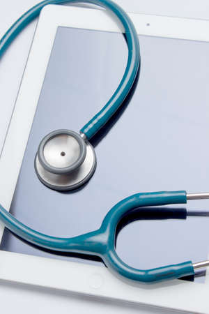 Healthcare and technology concept - close up of stethoscope and digital tablet pcの写真素材
