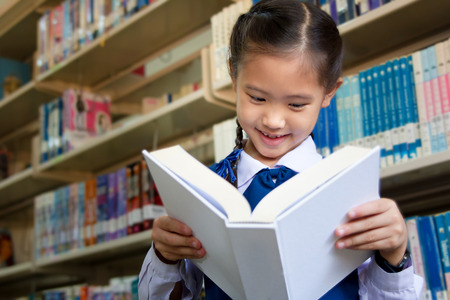 Asian little student in libraryの写真素材