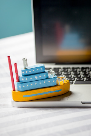 Ship toy on the laptop, travel concept.の写真素材
