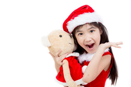 Portrait of little Asian girl in red Santa hat on white backgroundの写真素材