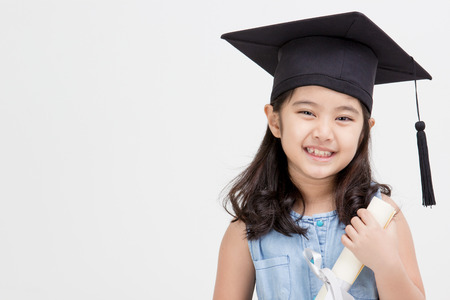 Happy Asian school kid graduate in graduation capの写真素材