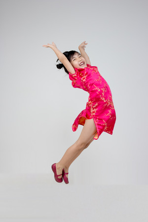 Portrait of happy little Asian child jumpingの写真素材