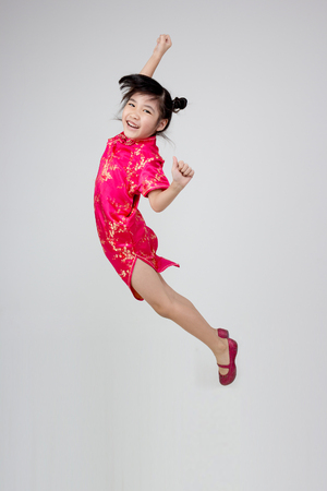 Portrait of happy little Asian child jumpingの写真素材