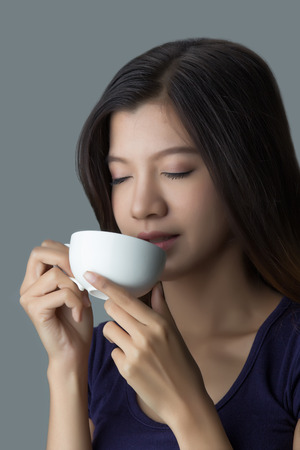 Beautiful Asian girl drinking coffeeの写真素材