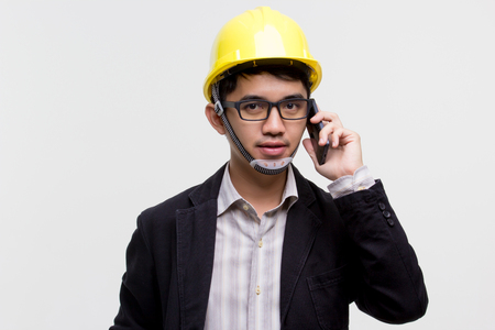Portrait of Asian engineer using smart phone on isolated backgroundの写真素材