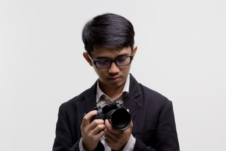 Asian photographer with camera on isolated backgroundの写真素材