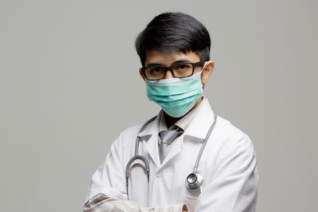 Portrait of Asian doctor wearing protective mask on his face on isolatedの写真素材