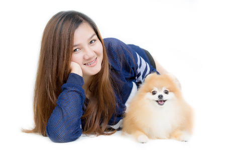 Portrait of Beautiful young Asian girl hugging a nice cute Pomeranian dogの写真素材