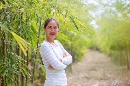 Portrait Of Beautiful Young Asian Woman Smiling in Green Bamboo Forest.の写真素材