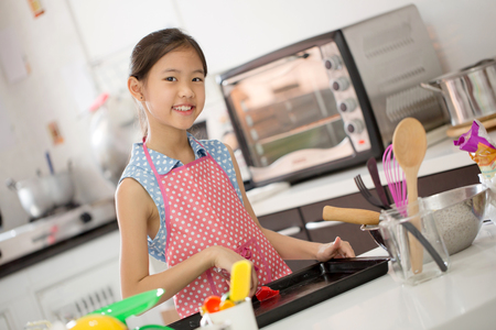 Little Asian cute chef cooking a bakery in kitchenの写真素材