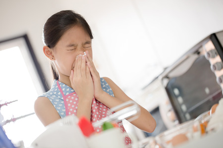Girl is blowing her nose, allergic to flourの写真素材