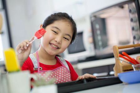 Little Asian cute chef cooking a bakery in kitchenの写真素材