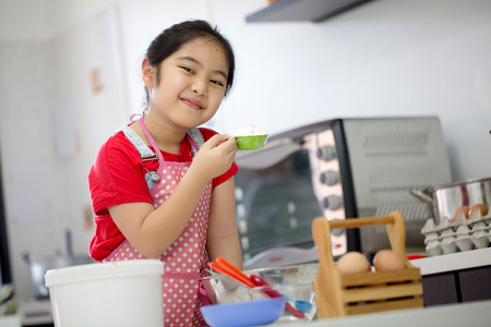 Little Asian cute chef cooking a bakery in kitchenの写真素材