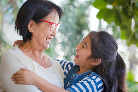 Happy little Asian girl hugging her grandmotherの写真素材